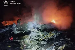 حريق كبير في مبنى سكني في منطقة زابوريجيزيا بأوكرانيا بعد هجوم بطائرة مسيرة روسية، مع وجود رجال إطفاء يعملون على إخماد النيران.