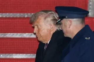 ترامب يسير برفقة ضابط، وسط أجواء متوترة عقب حادث إطلاق النار في مينيابوليس، مما يعكس الجدل حول سياسة الهجرة.