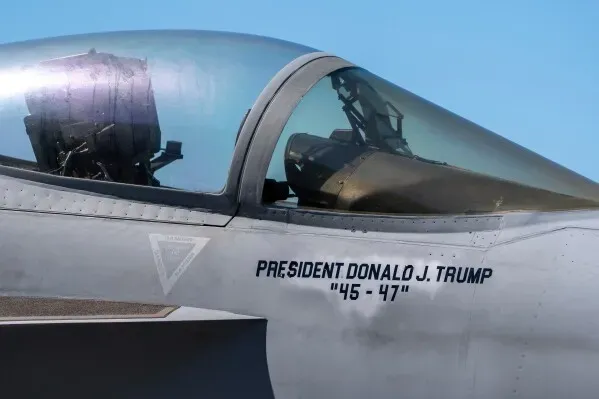 طائرة حربية تحمل اسم الرئيس دونالد ترامب، مع تفاصيل واضحة للقمرة. تعكس الصورة الاحتفال بالذكرى السنوية للبحرية الأمريكية.