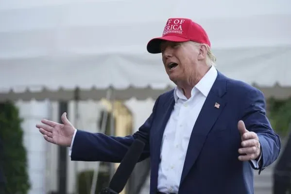 ترامب يتحدث خلال مؤتمر صحفي، مرتديًا قبعة حمراء مكتوب عليها "Make America Great Again"، معبرًا عن آرائه حول سياسة الهجرة.