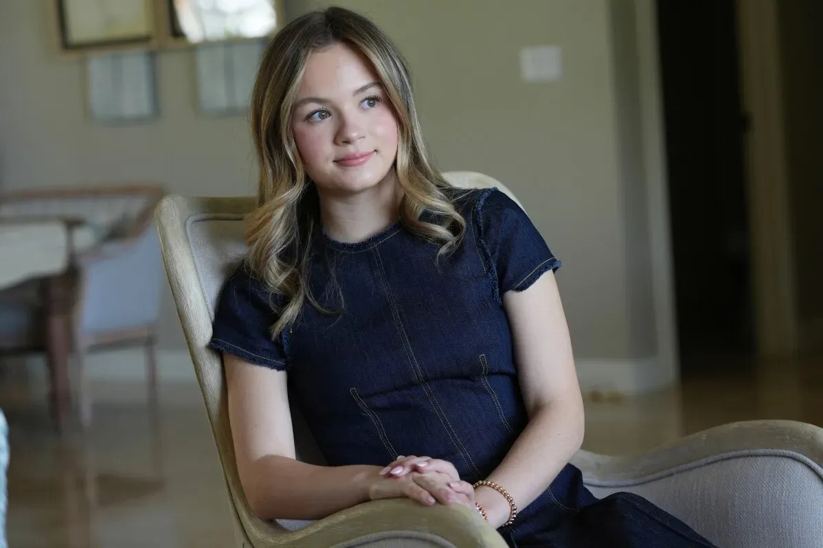 شابة تجلس في غرفة مضاءة، تعبر عن مشاعرها بعد تصريحات ترامب حول عُسر القراءة، مما يعكس تجاربها الشخصية مع التحديات التعليمية.