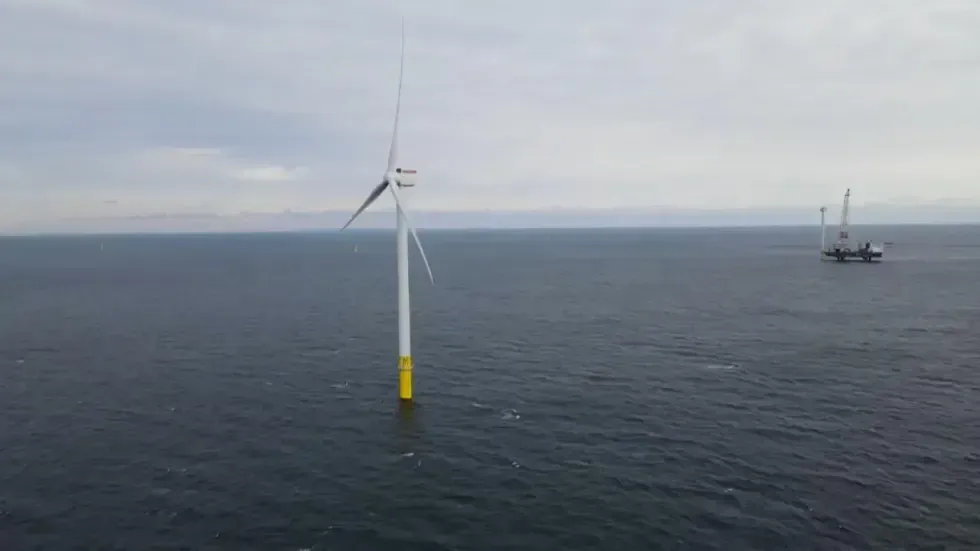 توربين رياح بحري في مشروع Empire Wind، مع سفينة دعم في الخلفية، يهدف لتوليد الطاقة لأكثر من 500,000 منزل.