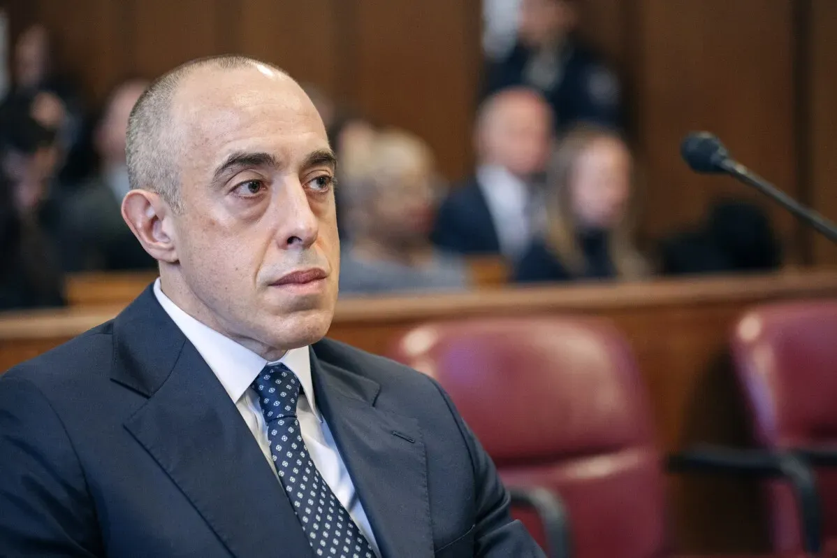 صورة لرجل يجلس في قاعة محكمة، يبدو عليه التركيز والجدية، وسط خلفية من المراقبين. تعكس الصورة أجواء التوتر المرتبطة بالقضايا القانونية.