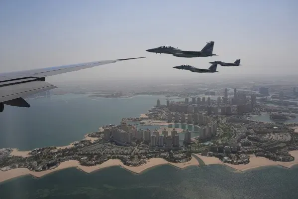 طائرات F-15 تابعة للقوات الجوية القطرية تحلق بجانب طائرة تجارية فوق مدينة الدوحة، مع مشهد ساحلي مميز.