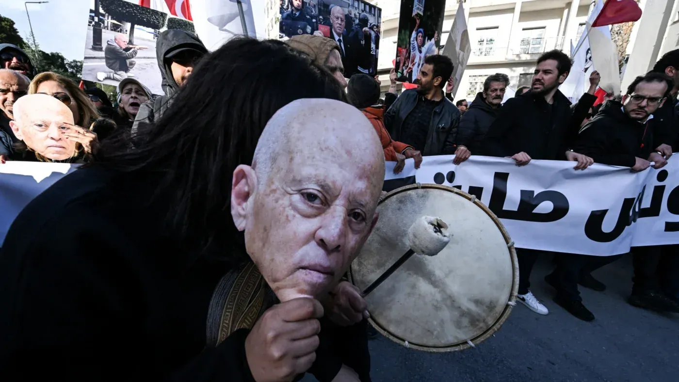 تظاهرة في تونس ضد الرئيس قيس سعيد، حيث يحمل المشاركون لافتات وصورًا تعبر عن مطالبهم بإطلاق سراح السجناء السياسيين.