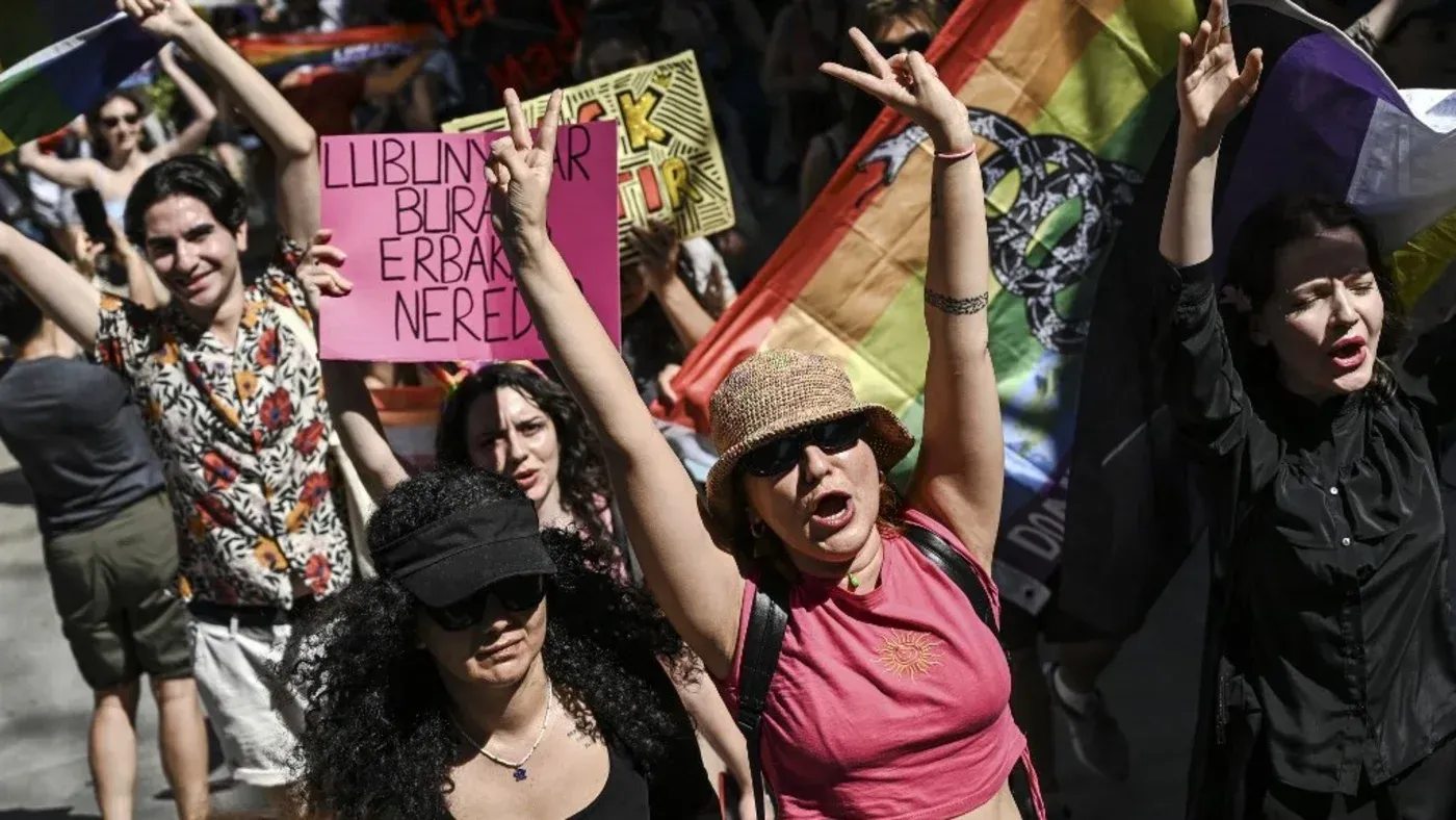محتجون يحملون لافتات وأعلام قوس قزح في مسيرة لدعم حقوق المثليين، تعبيرًا عن مقاومة التشريعات المعادية في تركيا.