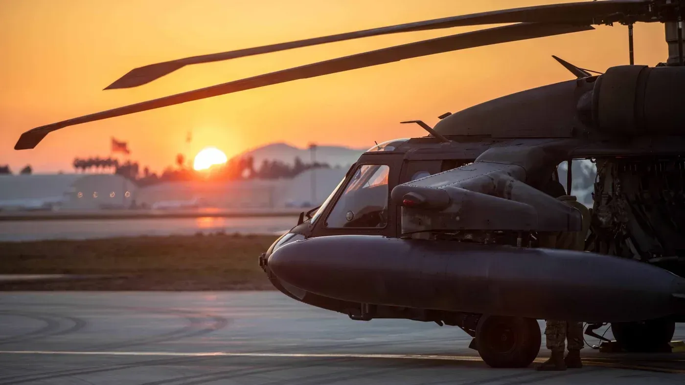 صورة لطائرة هليكوبتر عسكرية في قاعدة إنجرليك الجوية، مع غروب الشمس في الخلفية، تشير إلى التوترات الأمنية في المنطقة.