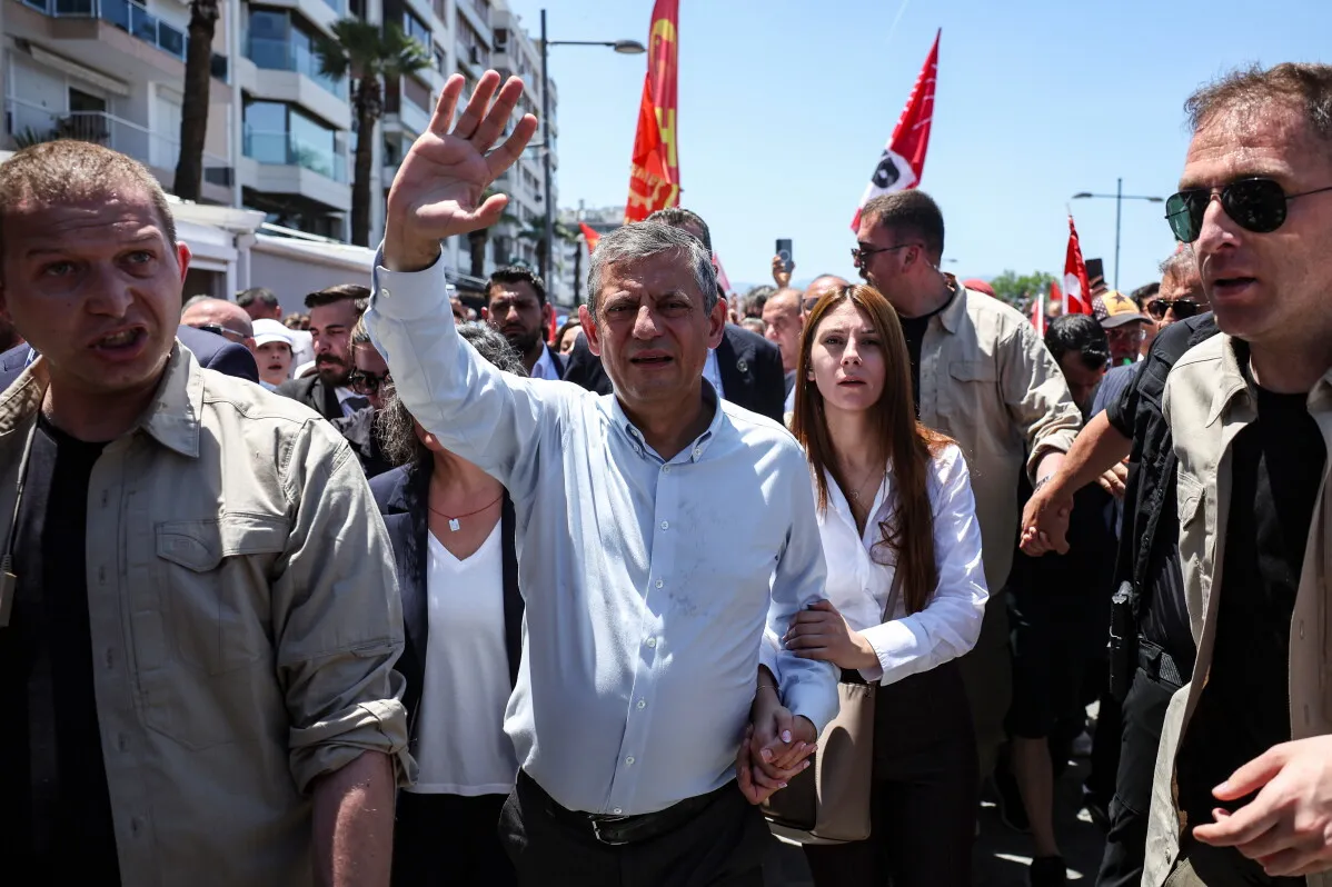 أوزغور أوزيل يلوّح بيده وسط حشد من المؤيدين خلال إعلان تأسيس حزبه الجديد لمواجهة أردوغان في تركيا.