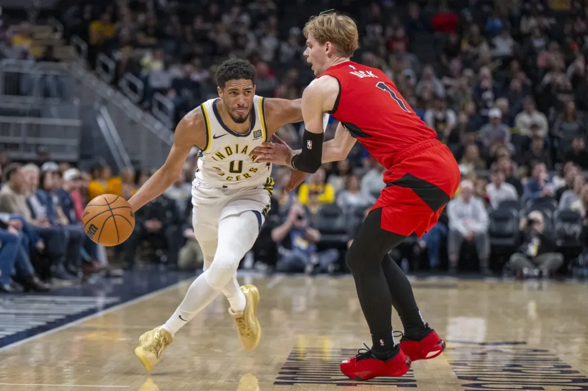 تايريس هاليبورتون يتجاوز مدافع تورونتو رابتورز، حاملاً الكرة، خلال مباراة NBA التي انتهت بفوز إنديانا بيسرز 111-91.
