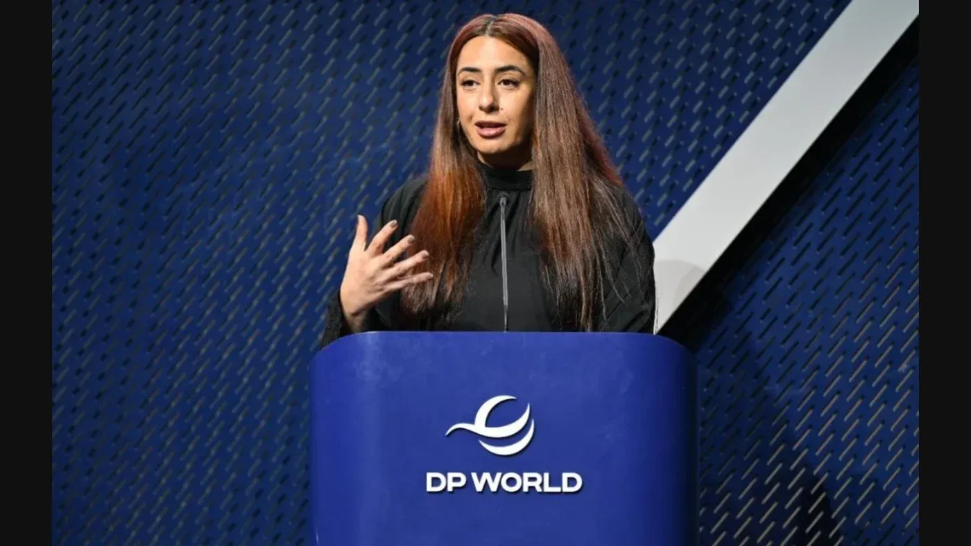 هند العويس، مسؤولة إماراتية، تتحدث في مؤتمر حول حقوق الإنسان، مع شعار DP World خلفها، في دبي.