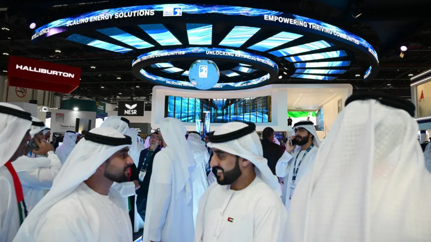 مؤتمر للطاقة في الإمارات، حيث يتجمع المشاركون في أجواء تفاعلية، مع لافتات تعرض تكنولوجيا الطاقة الحديثة.