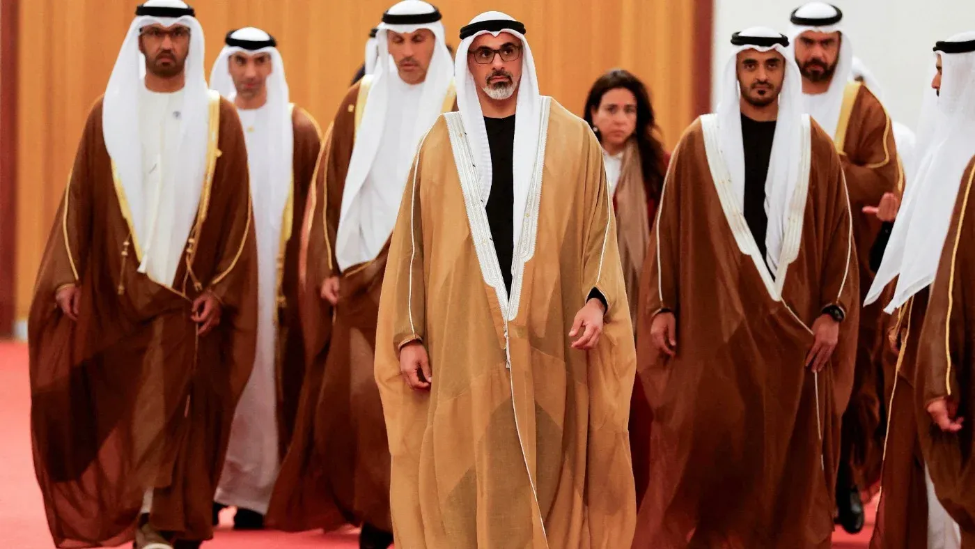 تظهر مجموعة من الرجال يرتدون الزي الإماراتي التقليدي، يتقدمهم شخصية بارزة، في سياق رسمي يعكس تأثير عائلة آل نهيان في السياسة الزراعية.