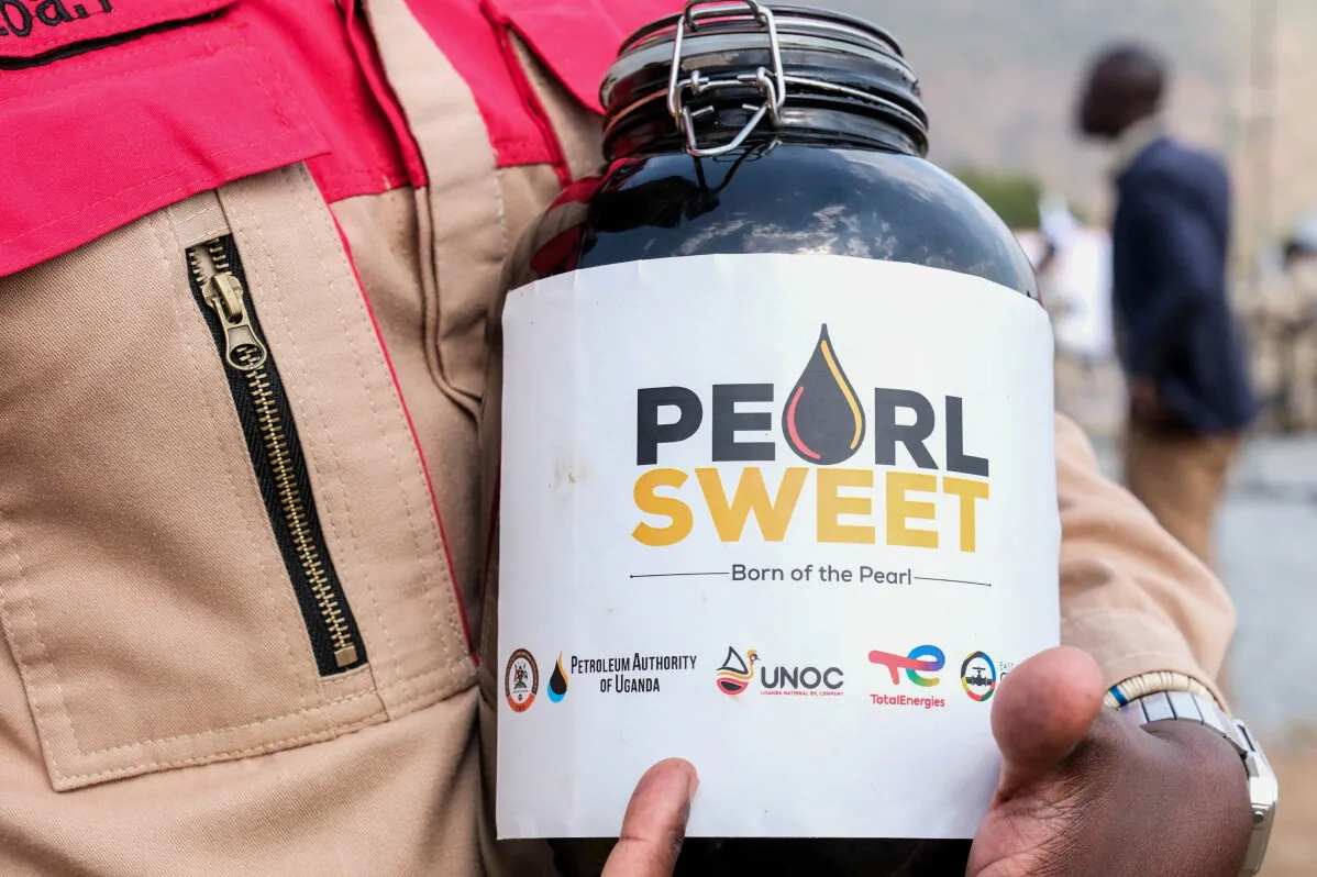 زجاجة تحمل شعار "Pearl Sweet" لمزيج النفط الخام الأوغندي الجديد، مع رموز شركات الطاقة والهيئات الوطنية.