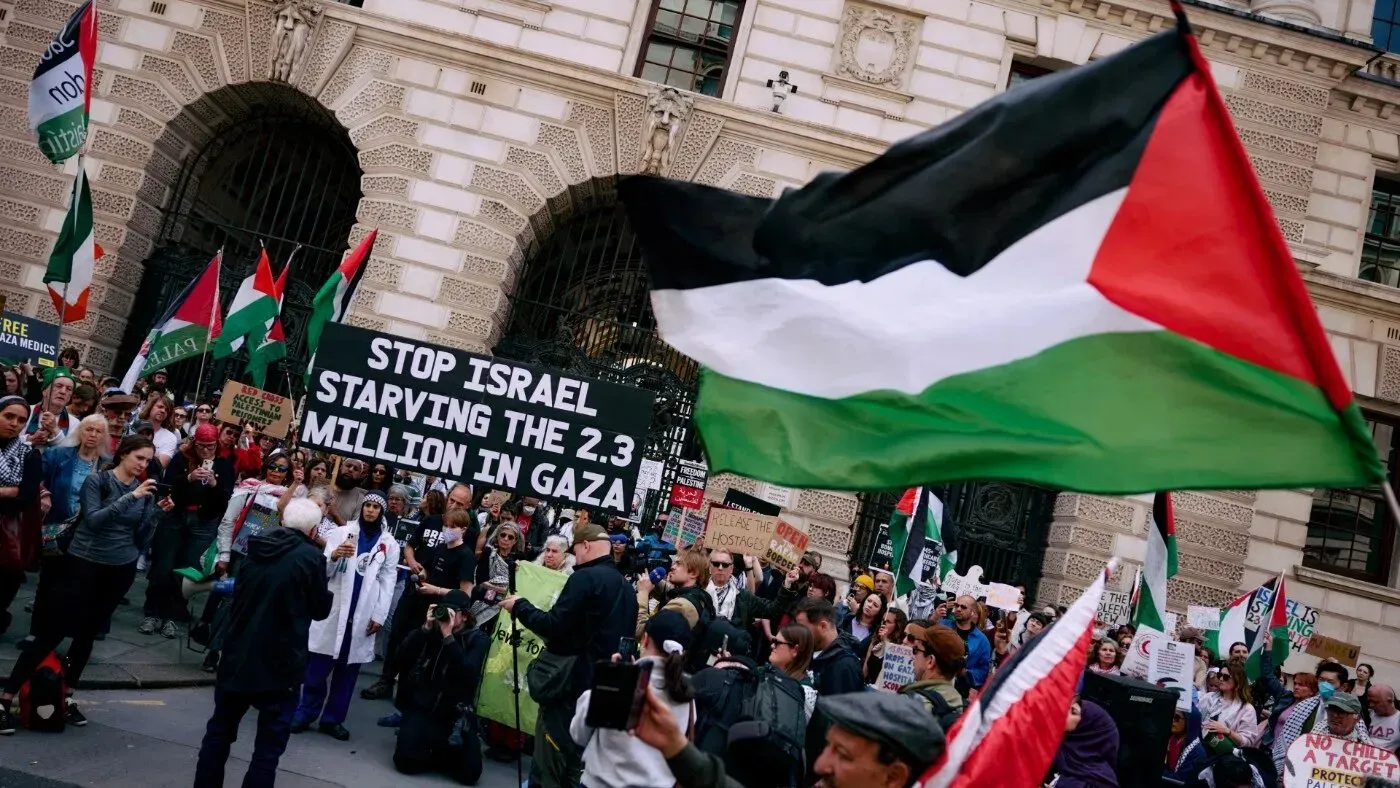 مظاهرة مؤيدة لفلسطين في لندن، حيث يحمل المتظاهرون لافتات تعبر عن دعمهم لغزة، مع العلم الفلسطيني يرفرف في المقدمة.
