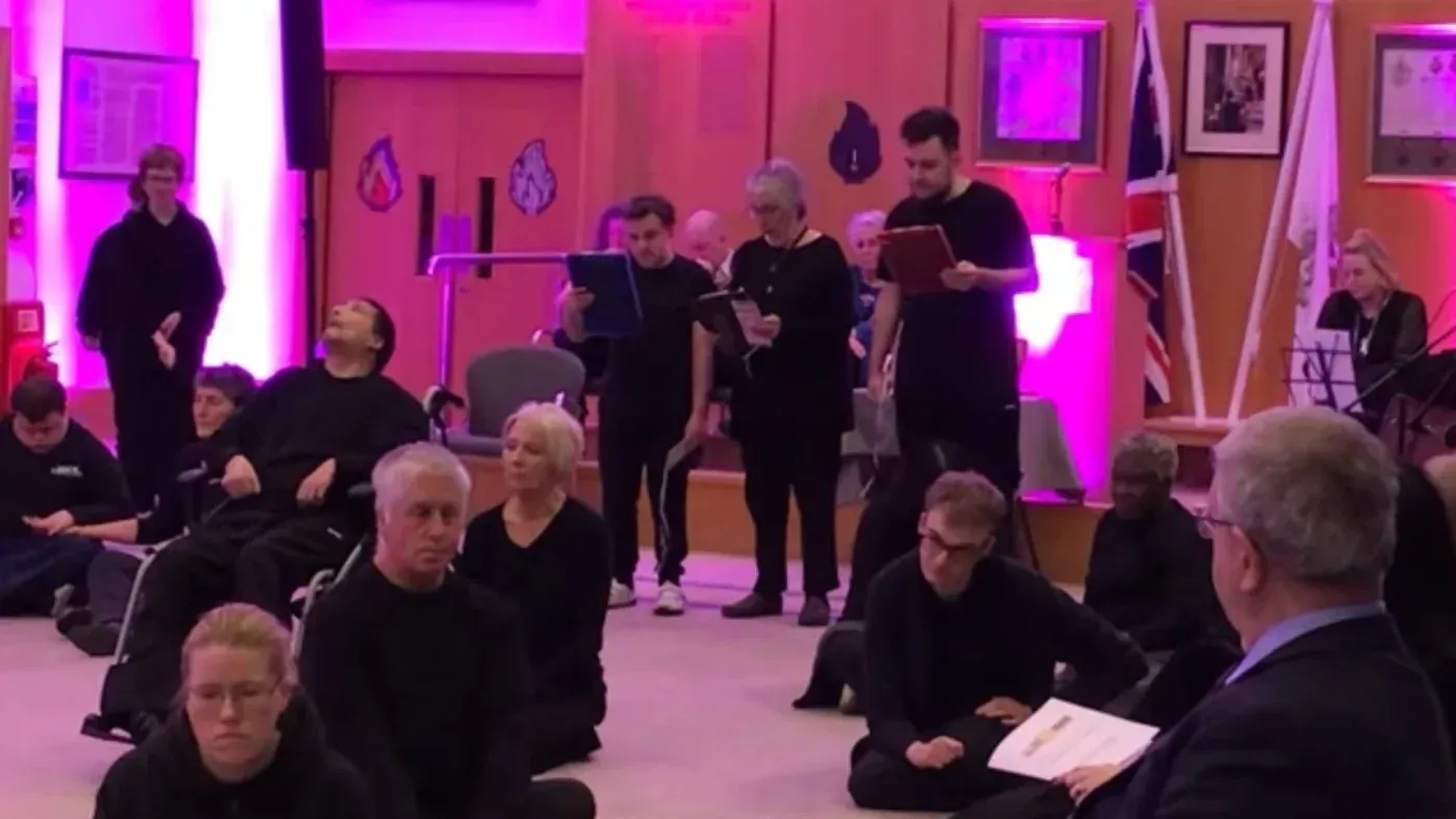 مجموعة من الممثلين في عرض درامي ضمن فعالية يوم ذكرى الهولوكوست، حيث يظهرون في ملابس سوداء ويقرأون نصوصًا.