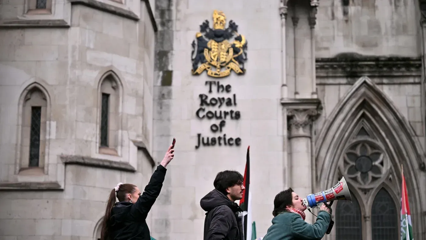 محتجون أمام المحكمة العليا في إنجلترا، يحملون لافتات ويستخدمون مكبر صوت للتعبير عن دعمهم لمنظمة العمل الفلسطيني بعد حكم قضائي تاريخي.