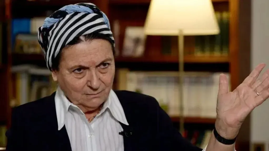 دانييلا فايس، الناشطة الاستيطانية، تتحدث في مقابلة مع خلفية مكتبة، مشيرة إلى مواقفها بشأن الاستيطان في الضفة الغربية.
