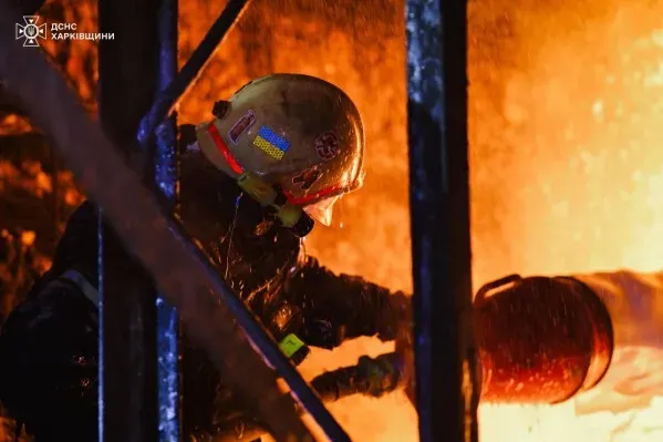 رجل إطفاء أوكراني يعمل على إخماد حريق في موقع دمار، وسط أجواء مشتعلة، مما يعكس جهود الإنقاذ خلال النزاع المستمر.