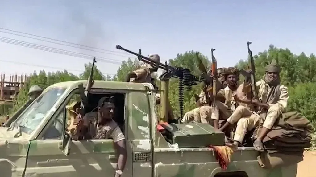 مقاتلون من قوات الدعم السريع في شاحنة عسكرية، يحملون أسلحة في منطقة متوترة بالسودان، وسط تصاعد الصراع والاتهامات بتورط الإمارات.