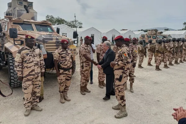 زيارة الأمين العام للأمم المتحدة أنطونيو غوتيريش لقوة قمع العصابات الجديدة في هايتي، حيث يتصافح مع الضباط العسكريين وسط أجواء من التوتر الأمني.