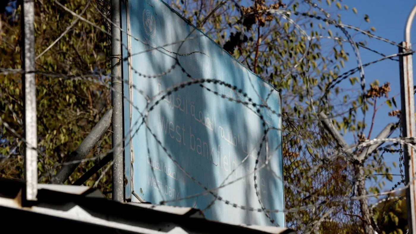 لافتة تشير إلى "الضفة الغربية" محاطة بسياج شائك، تعكس الوضع الإنساني والسياسي في المنطقة.
