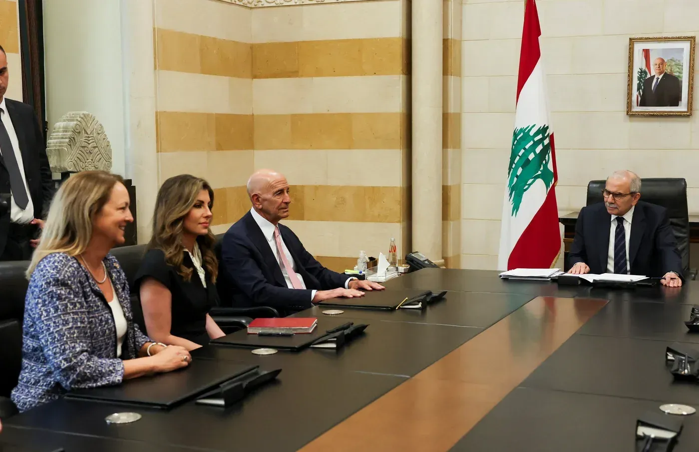 اجتماع رسمي في لبنان يضم مسؤولين، مع العلم اللبناني في الخلفية، يناقش قضية نزع سلاح الفصائل الفلسطينية.