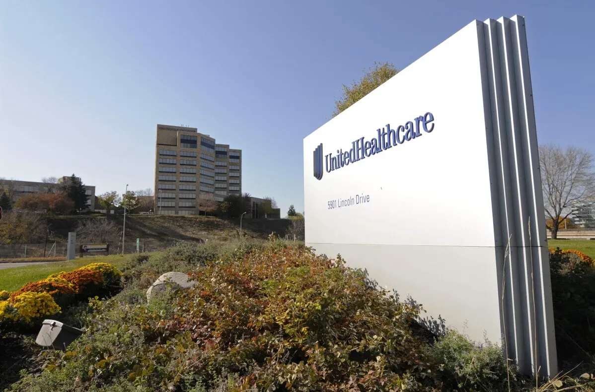 علامة شركة UnitedHealthcare على جانب الطريق، مع مبنى إداري خلفها. تعكس الصورة أهمية الشركة في قطاع التأمين الصحي.