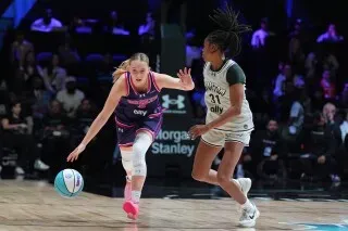 لاعبة كرة سلة تتنافس في مباراة احترافية، مع التركيز على المهارات والسرعة، في أجواء حماسية تعكس عودة كرة السلة النسائية إلى فيلادلفيا.