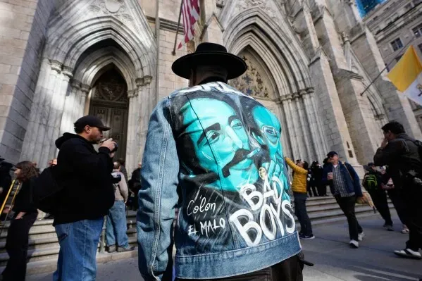 شخص يرتدي سترة جينز مزينة برسومات ويلي كولون وكلمات "BAD BOYS" أمام كاتدرائية القديس باتريك في نيويورك خلال مراسم تكريمه.