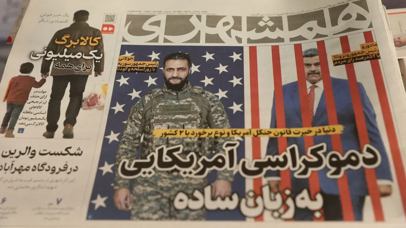 غلاف صحيفة إيرانية يظهر صورة للرئيس الفنزويلي نيكولاس مادورو مع خلفية تحمل الأعلام الأمريكية، مع تعليقات حول الأحداث السياسية.