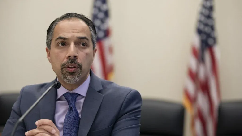 تريتا بارسي يتحدث خلال جلسة، مع وجود أعلام أمريكية خلفه، في سياق تحقيق إدارة ترامب بشأنه بسبب معارضته للحرب على إيران.