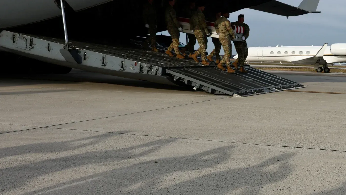 جنود أمريكيون يحملون تابوتًا أثناء إنزالهم من طائرة عسكرية، في سياق رد الولايات المتحدة على الهجمات في سوريا.