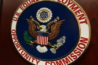 شعار لجنة تكافؤ فرص العمل الأمريكية، يظهر النسر الأمريكي مع درع يحمل الألوان الوطنية، يعكس جهود مكافحة التمييز في العمل.