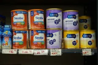 رفوف تحتوي على عبوات حليب الأطفال الصناعي من علامات تجارية مثل Similac وEnfamil، تعكس نتائج تحليل FDA حول سلامة المنتجات.