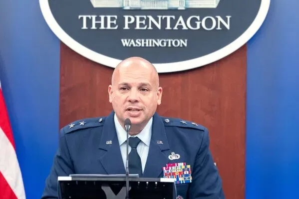 مسؤول عسكري يتحدث في مؤتمر صحفي في البنتاغون، مع شعار الوزارة خلفه، حول زيادة الإنفاق العسكري لمواجهة التهديدات الإيرانية.