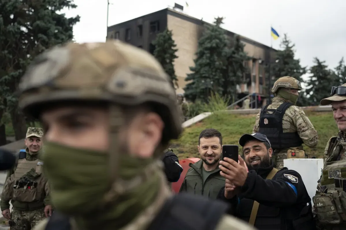 الرئيس الأوكراني زيلينسكي محاطًا بالجنود، مبتسمًا أثناء التقاط صورة سيلفي مع أحدهم، مما يعكس روح المعنويات العالية في ظل الحرب.