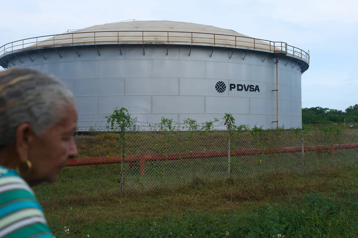خزان نفط تابع لشركة النفط الفنزويلية PDVSA في حزام أورينوكو مع امرأة في المقدمة، يعكس تحديات الاستثمار في النفط الفنزويلي.
