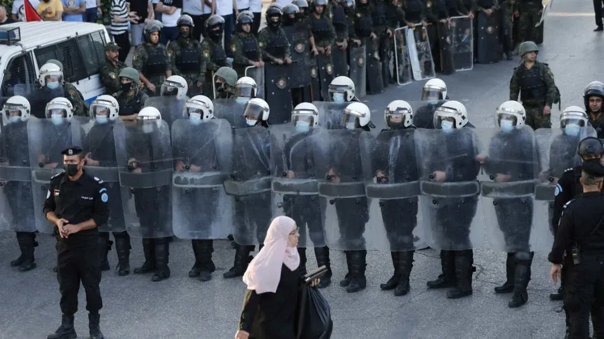 تظهر الصورة قوات أمن فلسطينية ترتدي دروعًا واقية وخوذًا، تتجمع في صفوف خلال احتجاجات، مما يعكس توتر الأوضاع في الضفة الغربية.