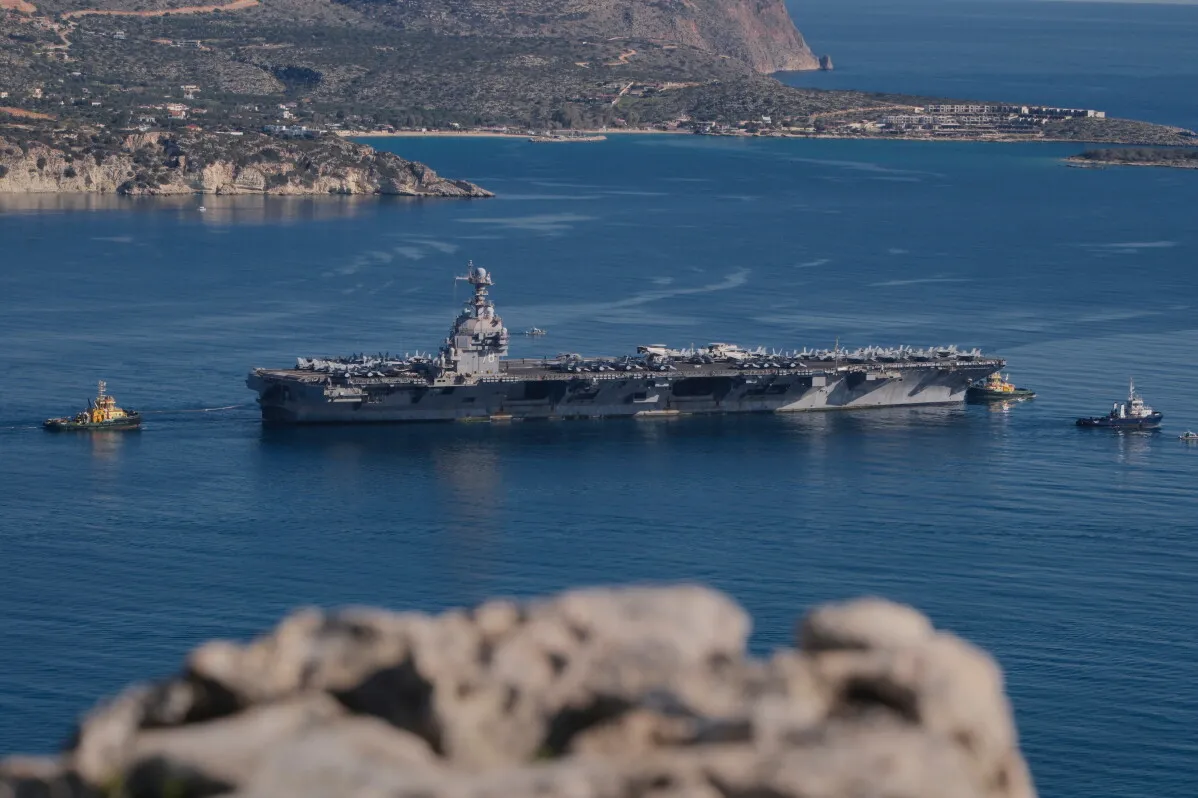 حاملة الطائرات الأمريكية USS George Washington تبحر في مياه هادئة بين الجبال، في مشهد يعكس انسحابها من المحيط الهادئ نحو الشرق الأوسط وسط توترات مع إيران.