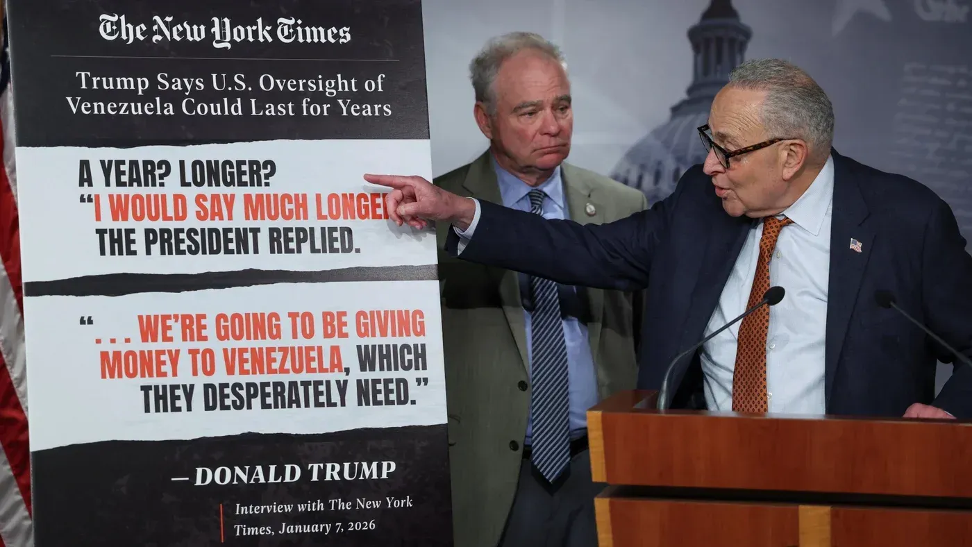 تصوير لسيناتور تشاك شومر يتحدث في مؤتمر صحفي، مع تيم كاين في الخلفية، حول قرار مجلس الشيوخ للحد من سلطات ترامب في فنزويلا.