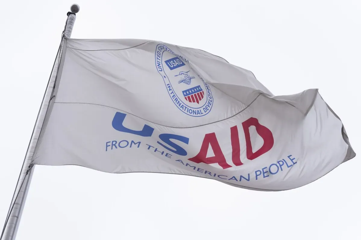 علم يحمل شعار الوكالة الأمريكية للتنمية الدولية (USAID) مكتوب عليه "من الشعب الأمريكي"، يرمز إلى جهود المساعدات الإنسانية العالمية.