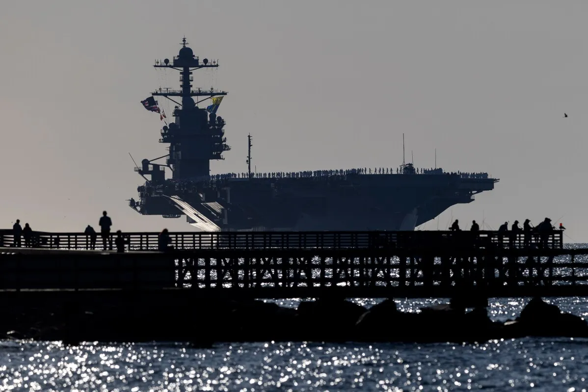 حاملة الطائرات USS Gerald R. Ford ترسو في قاعدة نورفولك بفيرجينيا، محاطة بالبحارة الذين ينتظرون لقاء ذويهم بعد انتشار طويل.