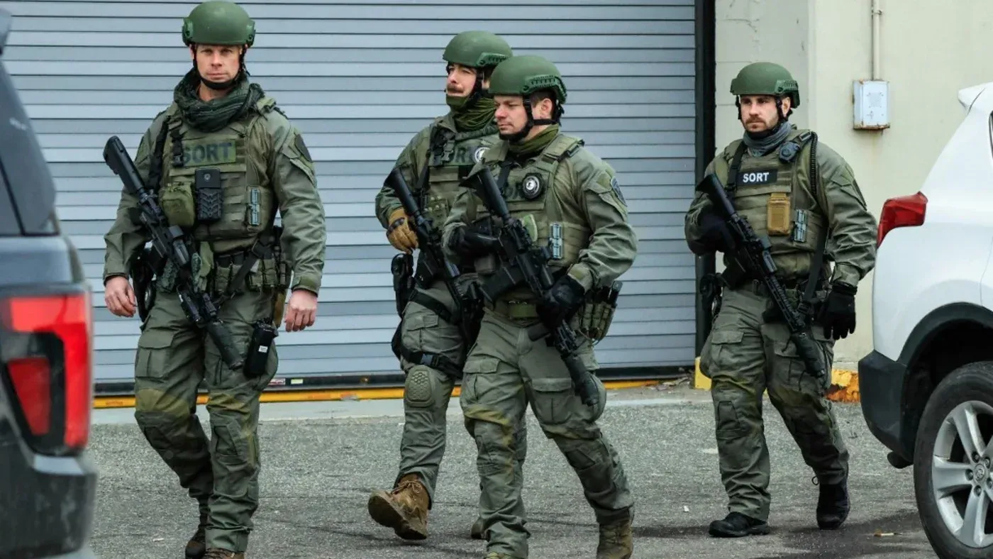 أفراد من وحدة خاصة يرتدون زيًا عسكريًا ويحمون أسلحة، يسيرون في منطقة حضرية، مما يعكس تصعيد التوترات السياسية في فنزويلا.