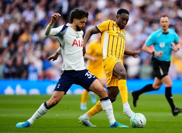 لاعبا كرة القدم Danny Welbeck وخصمه يتنافسان على الكرة في مباراة حماسية، حيث يرتدي Welbeck زي فريق Brighton بينما يرتدي الآخر زي Tottenham.