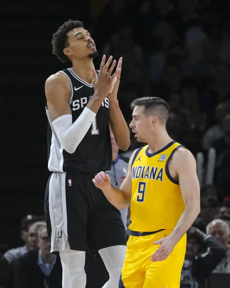 في الصورة، فيكتور ويمبانياما لاعب فريق سان أنطونيو سبيرز يقف بثقة أثناء مواجهة مع لاعب من فريق إنديانا. المباراة تعكس تفاصيل رحلة ويمبانياما في باريس.