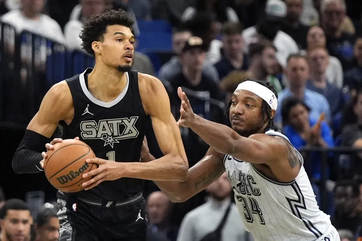 فيكتور ويمبانياما، نجم سان أنطونيو سبيرز، يت dribble الكرة أثناء مواجهة لاعب من الفريق المنافس في مباراة بالدوري الأمريكي للمحترفين.