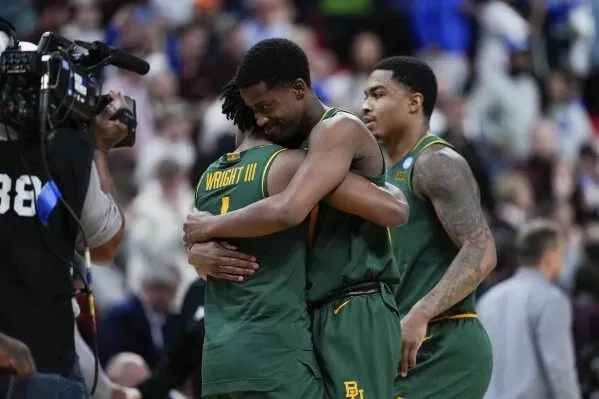 احتفال لاعبي بايلور بعد الفوز في مباراة NCAA، حيث يظهر اللاعبون يعانقون بعضهم البعض في لحظة فرح.