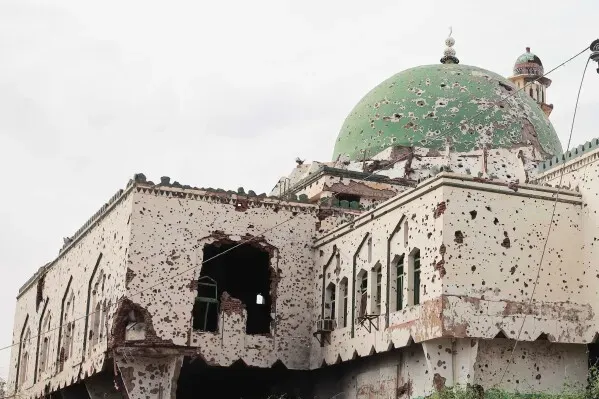 مبنى مدمر في الخرطوم يظهر آثار الحرب، مع جدران مثقوبة وقبة خضراء، يعكس الدمار الذي خلفته النزاعات المسلحة في المنطقة.