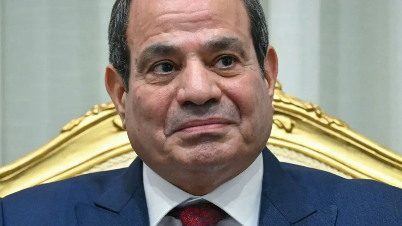 صورة لرئيس مصر، عبد الفتاح السيسي، وهو يجلس على كرسي مزخرف، يعكس تعبيره الجدي في سياق الأحداث الإقليمية الراهنة.