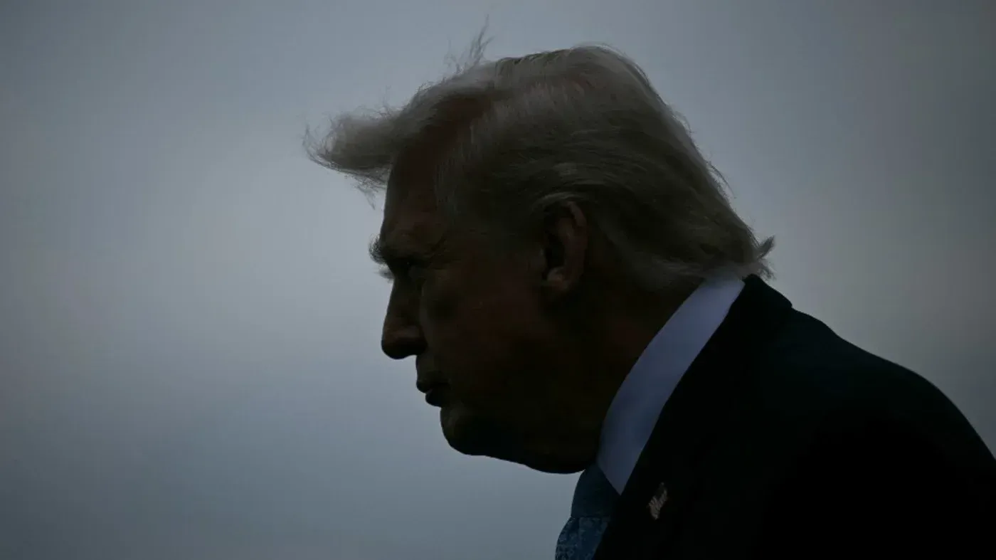 صورة جانبية لرجل يبدو أنه يتحدث بجدية، مع خلفية داكنة تعكس أجواء التوتر السياسي والاقتصادي.